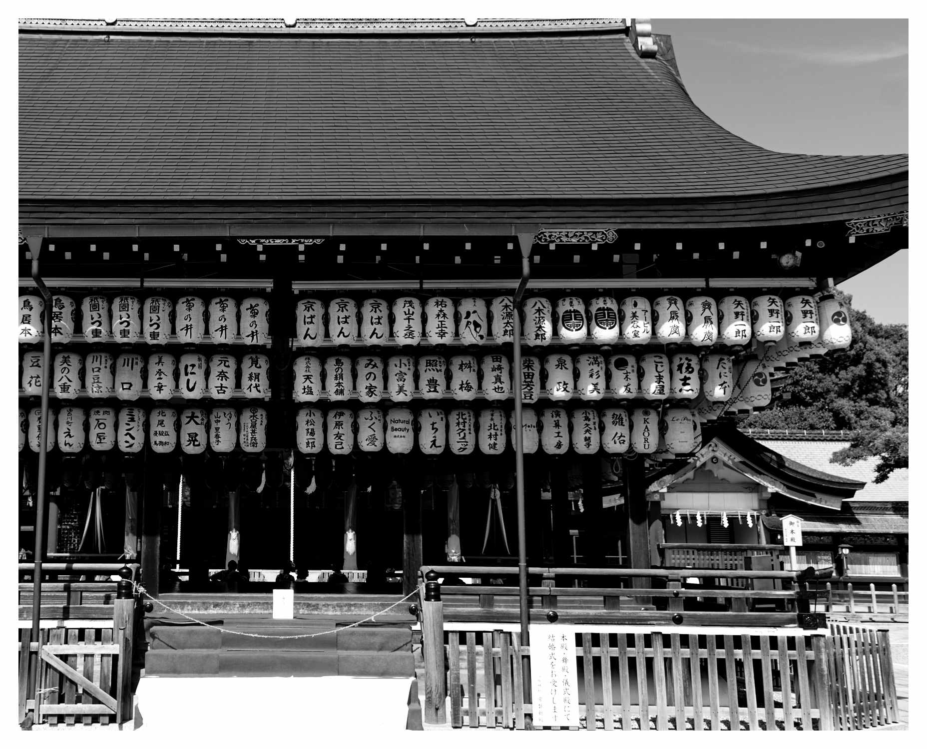 Black and white photo of traditional Japanese paper lanterns hanging at Yasaka shrine in Kyoto, Japan