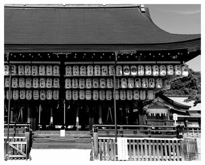 Black and white photo of traditional Japanese paper lanterns hanging at Yasaka shrine in Kyoto, Japan