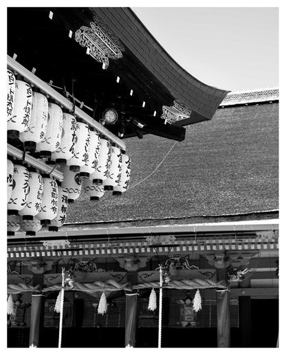 Black and white photo of traditional Japanese paper lanterns hanging at Yasaka shrine in Kyoto, Japan