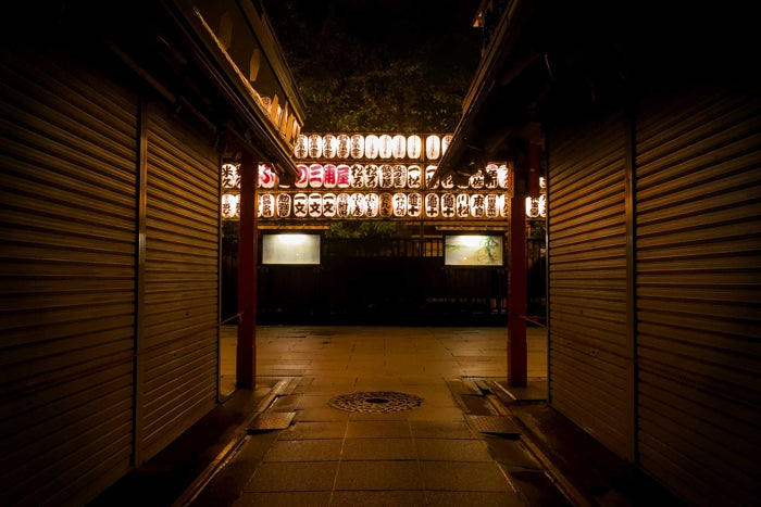 Paper lanterns cast warm light in the middle of the night over the walkway of the Sensoji Temple in Tokyo, Japan