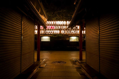 Paper lanterns cast warm light in the middle of the night over the walkway of the Sensoji Temple in Tokyo, Japan